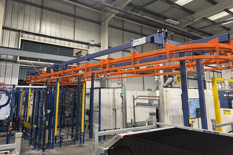 MCM Autotrack Hängeförderanlage und Tragkonstruktion MCM Autotrack orange overhead conveyor track supported by blue steel framework in an automotive production facility