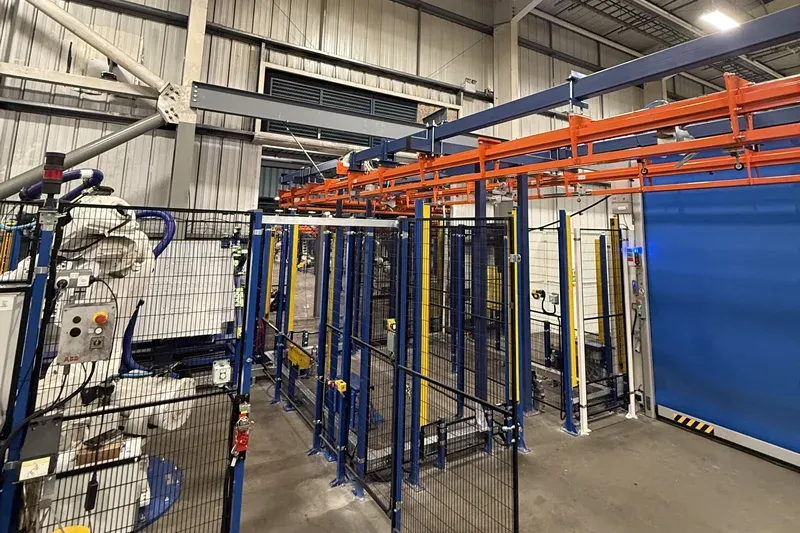 MCM Autotrack Förderband integriert in Automobilproduktionsanlagen Amber Industries overhead conveyor installation positioned above automated automotive manufacturing equipment